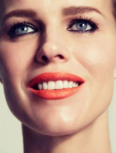 a woman with bright orange lipstick on her lips