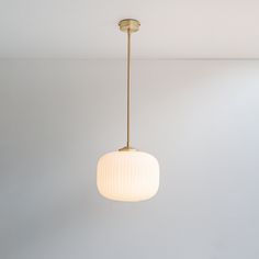 a light fixture hanging from the ceiling in a room with white walls and flooring