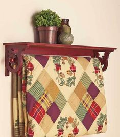 a potted plant sitting on top of a wooden shelf next to a decorative wall hanging