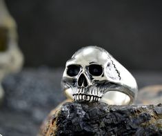 ** Handmade skull ring in solid Sterling silver Contemporary style representation of a human skull with a glossy mirror finish handmade or with grated and nuanced textures to mark volumes. With a strong and solid ring bridge to last a lifetime. ** APPROXIMATE MEASURES (they are always approximate since this ring is handmade and each one we make is unique) CRANEO: 15.40m wide / 17.2 high RING BRIDGE: 6.5mm wide / 2mm thick APPROXIMATE WEIGHT: 12.5 gr. ** For people who want to wear a skull ring b