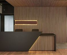 an office with wooden walls and black desks