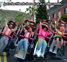 a group of people riding on top of skateboards down a street with arms in the air