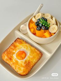 an egg and fruit dish on a white plate next to a small bowl of fruit