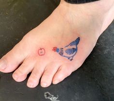 a foot with a bird and apple tattoo on it