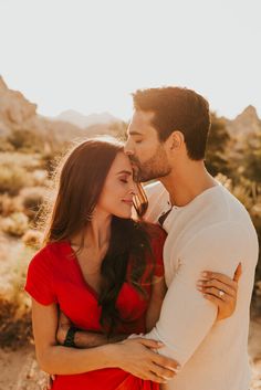 a man and woman embracing each other in the desert