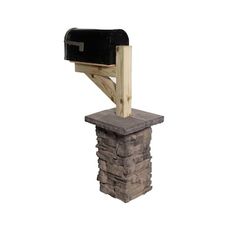 a black mailbox sitting on top of a stack of bricks