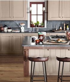 two stools sit at the center of a kitchen island