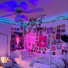 a bed room with a neatly made bed and lots of pictures on the wall above it