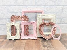 four different colored frames sitting on top of a wooden table