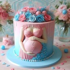 there is a cake that has a pregnant woman on it and flowers in the background