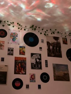 there are many records on the wall with plants growing out of them and hanging from the ceiling