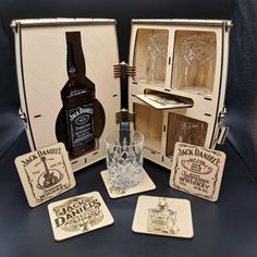 an assortment of liquor bottles and coasters in a wooden case with matching coasters