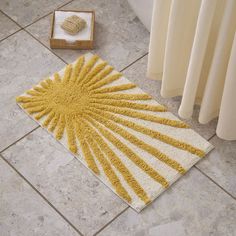 a yellow and white rug sitting on top of a tile floor next to a radiator