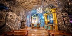 the inside of a church with benches and chandeliers