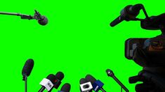 several microphones are lined up in front of a green screen