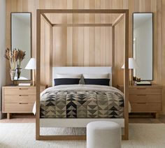 a bedroom with a bed, dressers and mirror on the wall next to it