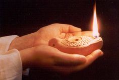 a person holding a lit candle in their hand with the words store on it's side