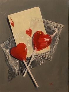 two lollipops are sitting on top of a piece of paper and one is in the shape of a heart