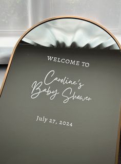 a welcome sign for a baby shower in front of a window