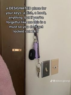 there is a key hanging on the wall next to a door with a quote about it