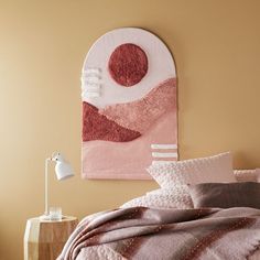 a bed in a bedroom with a pink comforter and pillows on top of it