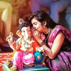 a woman kneeling next to an elephant figurine on top of a red table