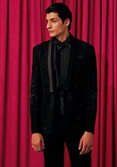 Step into sophistication with our Black Wave Embroidered Tuxedo Set. This exquisite ensemble features a shimmering textured blazer adorned with intricate hand-embroidered waves, paired with a crisp black pintuck shirt, bow tie, sash, and pants. Perfect for formal occasions like weddings, cocktail parties, or elegant dinners. Experience unparalleled style and elegance with our Black Wave Embroidered Tuxedo Set. Components : 5 (Blazer, Shirt, Bowtie, Sash and Pants) Composition : Textured Suiting Care: Dry Clean Only and Vacuum Storage This product can be customized for sleeves, length of blouse and neckline Delivery : 4-6 weeks as the product is hand crafted. Check Size Guide or choose MySize for free customisation (All Sizes above XL can be made at 15% additional cost) For more information Embroidered Waves, Suits For Men Wedding, Embroidered Tuxedo, Tuxedo Suit For Men, Pintuck Shirt, Suit For Men Wedding, Elegant Dinners, Modern Tuxedo, Designer Tuxedo