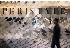 a man walking past a display window with geometric shapes