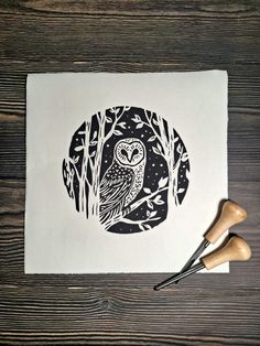 an owl is sitting on top of a piece of paper next to some wood stamps