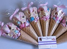 an ice cream cone filled with marshmallows and star shaped candies in wrappers