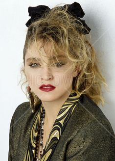 a close up of a person with long hair and a necklace on her neck wearing a black bow