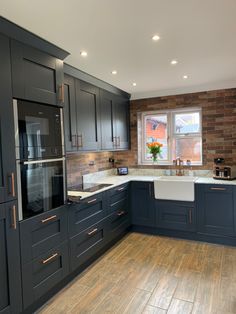 a kitchen with wood flooring and blue cabinets in the center, along with a window