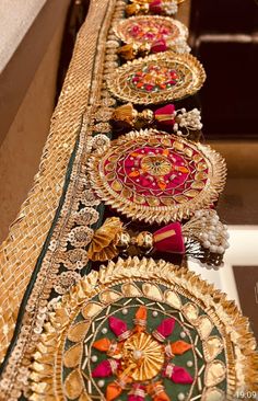 many different colored and gold designs are on the long table cloth, along with other decorative items