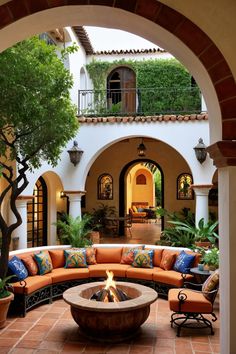 an outdoor living area with couches and a fire pit in the middle of it