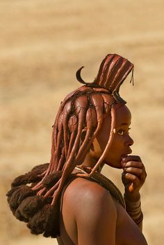 a woman with dreadlocks standing in the desert