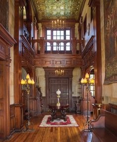 a large room with wood paneling and chandeliers on either side of the door