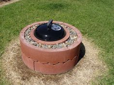 a fire pit sitting in the middle of some grass