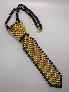 Black and Gold Pearl neck tie High quality gold pearls! Formal Black Beaded Necklace, Black Jewelry With Ties For Gifts, Black Ties Jewelry For Gift, Gift Black Jewelry With Ties, Elegant Gold Ties For Party, Elegant Gold Jewelry For Black Tie, Luxury Gold Tie For Formal Occasions, Elegant Gold Jewelry For Black Tie Event, Gold Adjustable Suit And Tie Accessories For Party