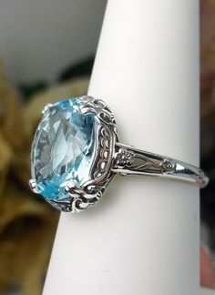 Formal Cushion Cut Topaz Ring With Gemstone Accents, Classic Light Blue Topaz Ring For Formal Occasions, Light Blue Oval Ring With Prong Setting, Elegant Oval Solitaire Topaz Ring, Classic Sapphire Ring With Gemstone Accents For Wedding, Elegant Round Topaz Ring With Gemstone Accents, Oval Topaz Ring With Center Stone For Formal Occasions, Oval Topaz Wedding Ring, Cushion Cut Wedding Rings With Gemstone Accents