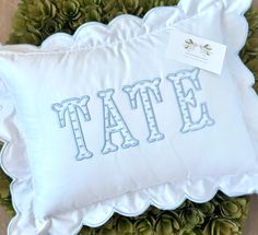 a white pillow with the word tate on it