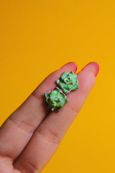 Upgrade your accessory game with these charming succulent stud earrings! Handcrafted by skilled artisans, these earrings are perfect for any plant lover looking to add a touch of nature to their look. Each earring features a vibrant and realistic succulent charm made from durable clay, coated with color-fading paint, and sealed with non-toxic varnish for long-lasting wear. The stud posts are embedded directly into the charm itself for added security, ensuring that these earrings won't easily break or come apart. We use non-corrosive, lead and nickel-free stainless steel earring studs to avoid allergies for those with sensitive ears. These earrings are also perfect for those searching for eco-friendly jewelry, as they are made with sustainable materials. Each pair of succulent earrings come Small Green Earrings For Gift, Nature Stud Earrings, Tiny Green Earrings For Gift, Nature-inspired Green Flower Earrings For Gifts, Polymer Clay Succulent Earrings, Plant Themed Earrings, Polymer Clay Earrings Succulents, Plant Themed Stud Earrings, Succulent Earrings