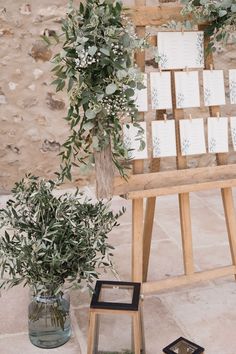 a wooden easer with cards on it next to a potted plant and an empty card holder