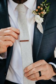 a man wearing a suit and tie with a boutonniere on his lapel