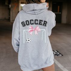 Hey soccer stars! Show off your game-day style with our "Soccer" Coquette Hoodie Sweatshirt. Whether you're on the field, traveling for tournaments, or just hanging out, this hoodie is your perfect companion for staying cozy and looking chic.  Makes an adorable team hoodie for your travel or fall soccer team too! Girls Soccer Hoodie Sweatshirts: Tailored for the dedicated soccer girls, this hoodie combines ultimate comfort with sporty style. It's perfect for those early morning practices, late-night games, and everything in between. Soccer Hoodie Sweatshirts: Made with a plush blend of 50% cotton and 50% polyester, this sweatshirt feels incredibly soft and warm. The medium-heavy fabric (8.0 oz/yd²) ensures you stay snug and comfortable no matter the weather. Travel Soccer Hoodie Sweatshirt Team Spirit Hoodie With Drawstring Hood For Game Day, Team Spirit Sports Event Hoodie, Game Day Sports Fan Fleece Hoodie, Sports Fan Fleece Hoodie For Game Day, School Spirit Long Sleeve Hoodie For Sports Season, Sports Fan Long Sleeve Hoodie, Sporty Hooded Sweatshirt For Game Day, Sporty Athletic Heather Hoodie With Letter Print, Sporty Hoodie With Letter Print In Athletic Heather