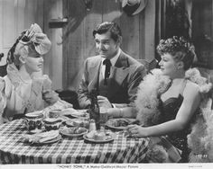 three people sitting at a table with plates of food