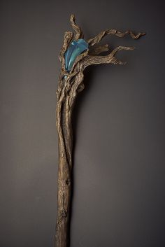 a tree branch with a blue stone in it's center, against a dark background