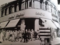 an old black and white photo of people in front of a store