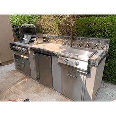 an outdoor kitchen with stainless steel appliances and granite counter tops