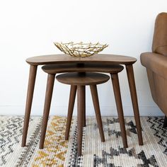 two wooden tables sitting on top of a rug next to a chair and couch in a room