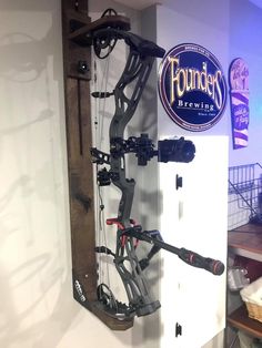 a wall mounted archery rack in a room with a sign on the wall behind it